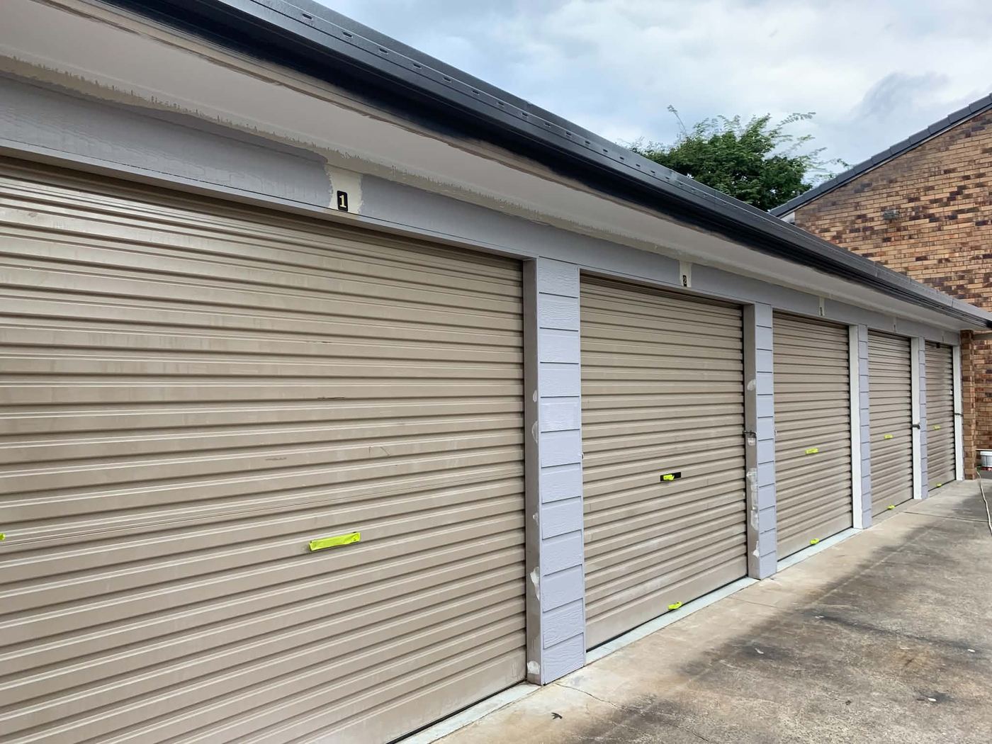 Strata garage doors in faded beige before repaint